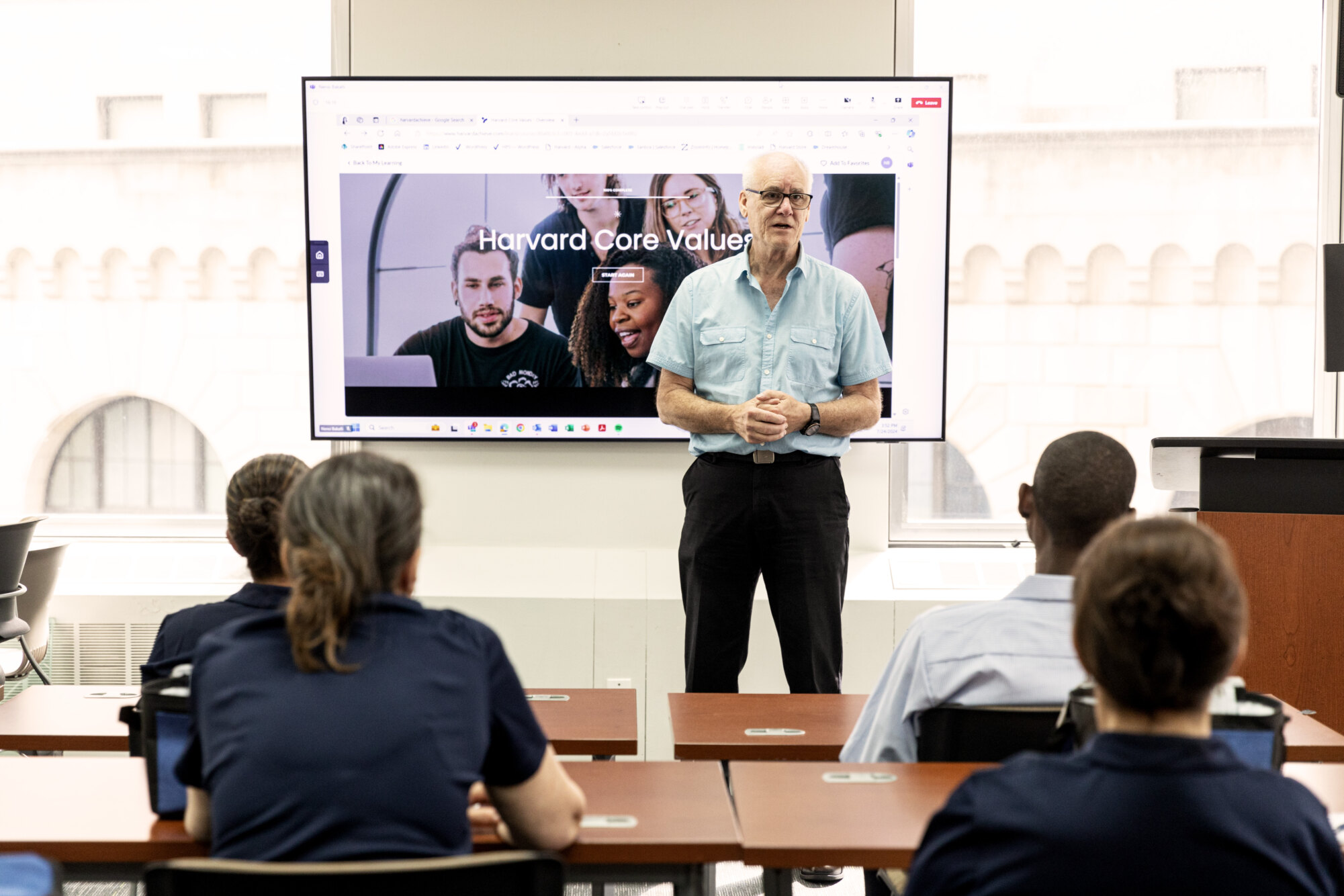 Man giving a presentation to seated audience in a classroom.